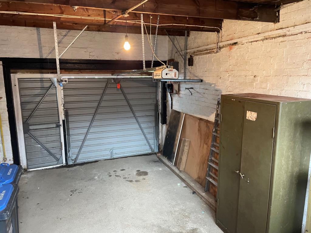 Lot: 156 - RETAIL UNIT AND WORKSHOP WITH GARAGE AND TWO FLATS - internal of garage with up and over electric door